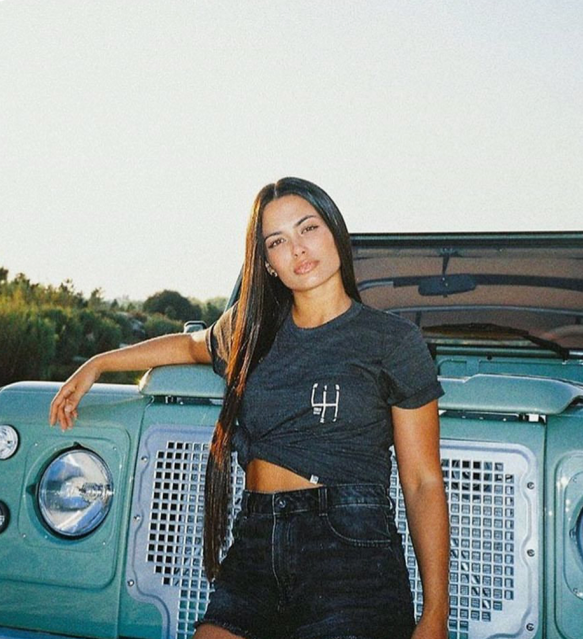 Woman in front of mint green Defender