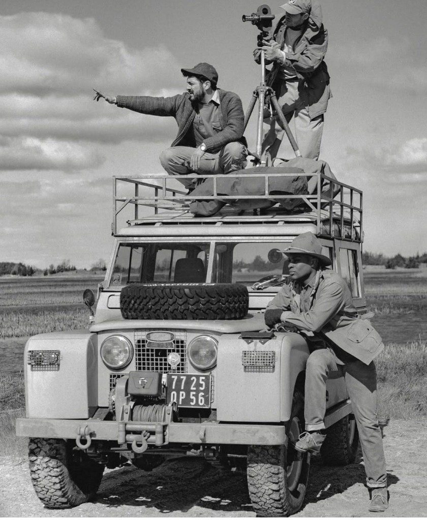 Vintage Land Rover expedition with crew and camera on roof rack