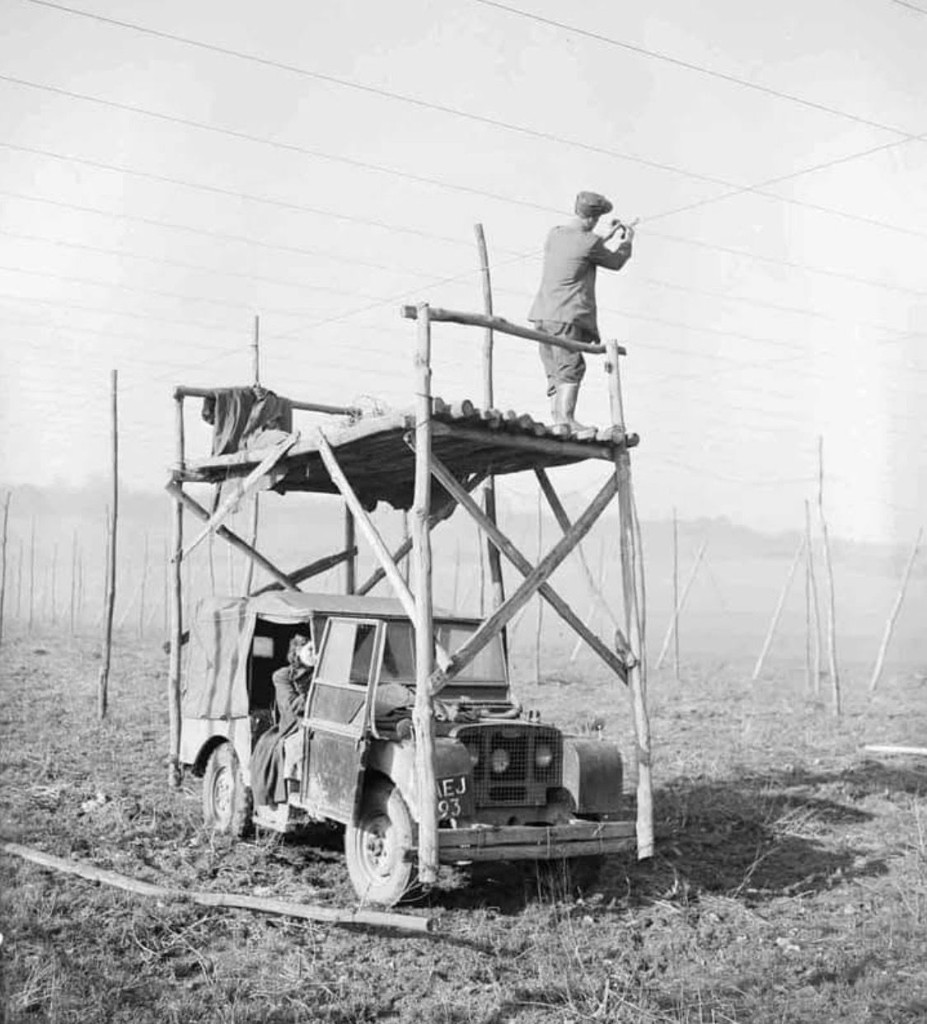 Land Rover with wooden scaffolding in hop field