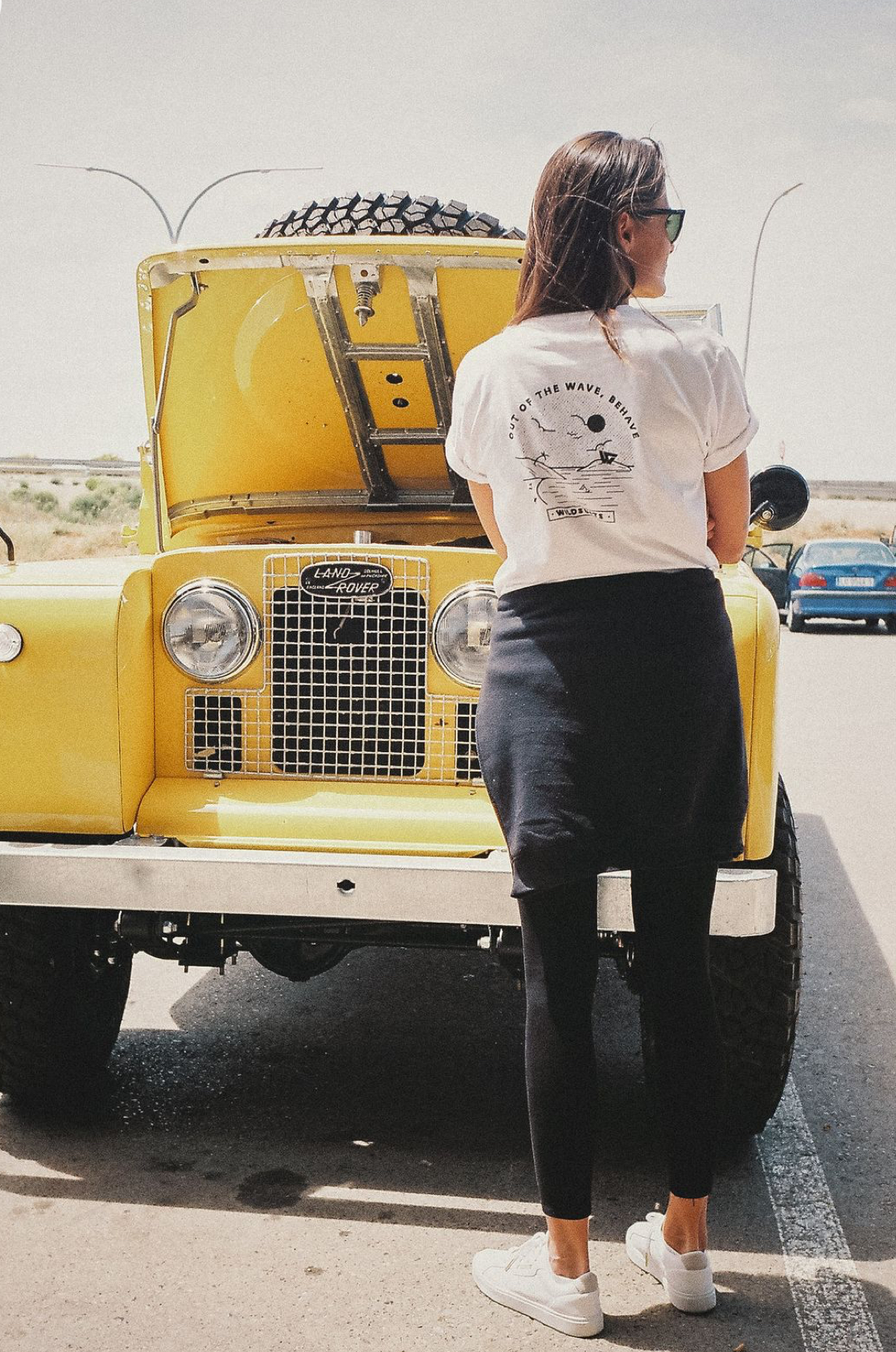 Woman with vibrant yellow vintage Series Land Rover