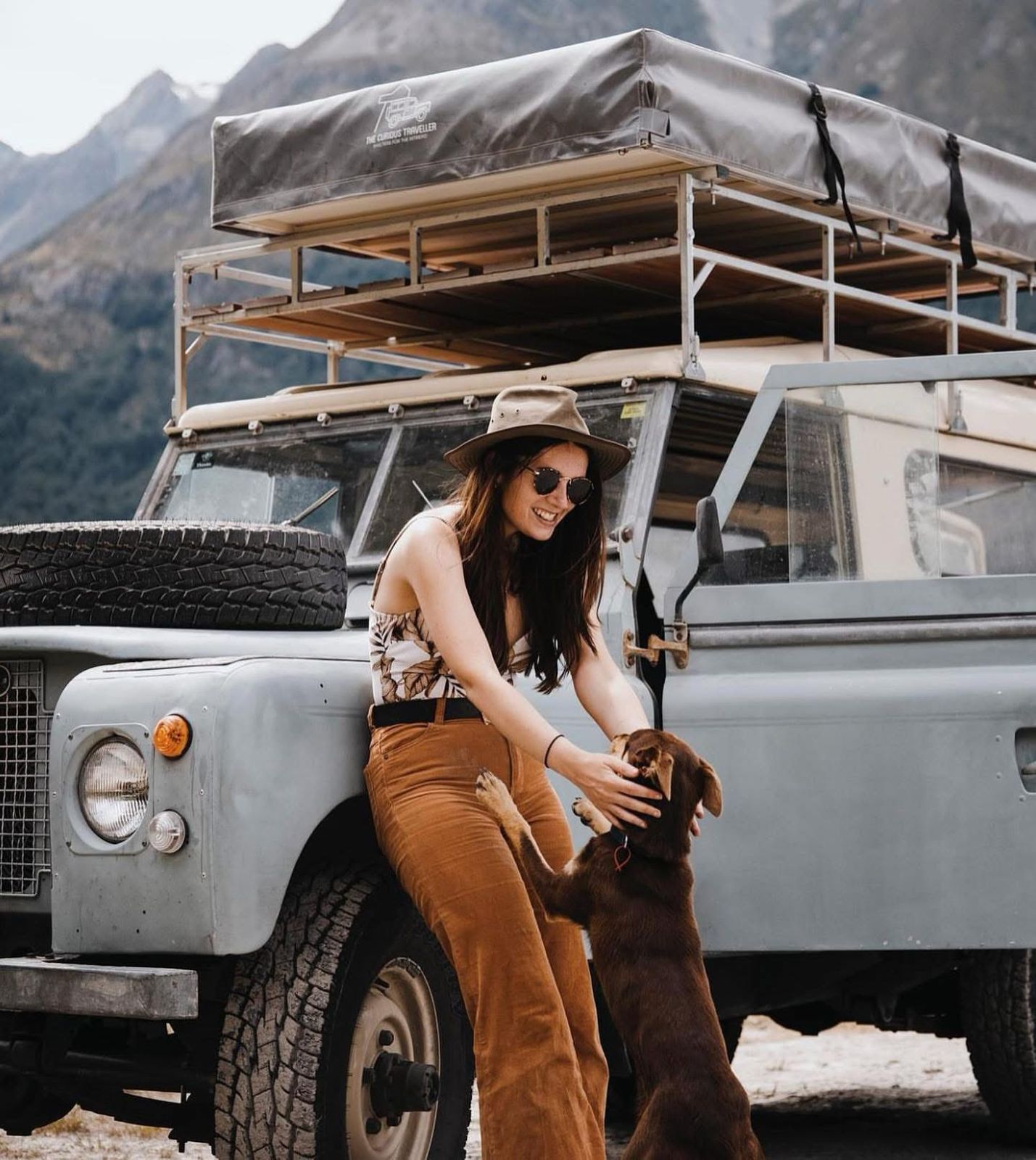 Classic Land Rover with rooftop tent in mountains