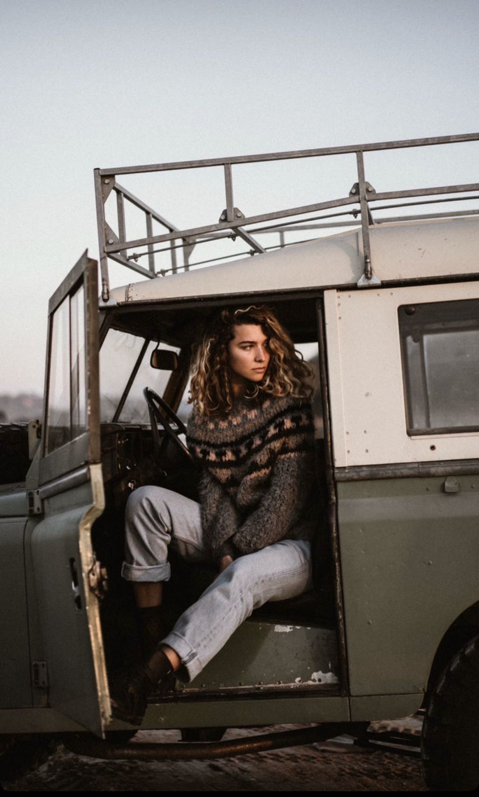 Sage green Defender with cream roof, woman in driver seat