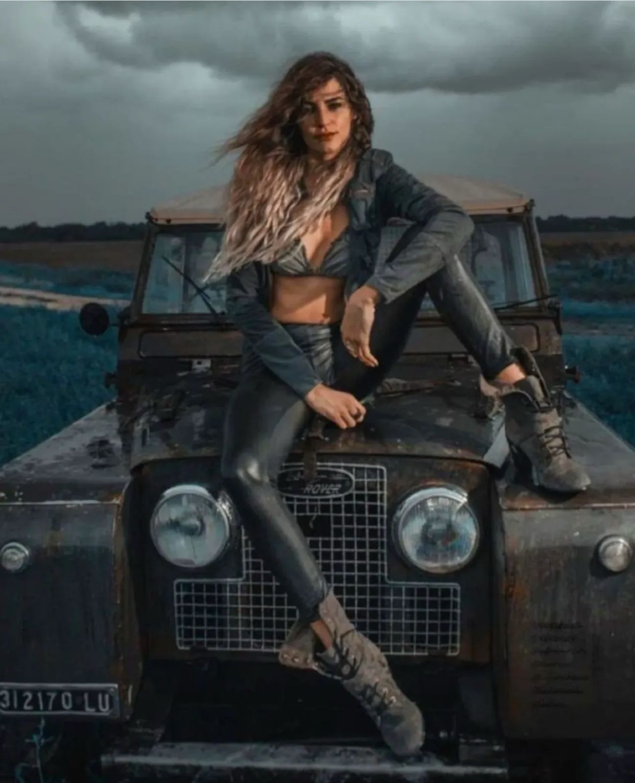 Weathered classic Series Land Rover with woman on hood