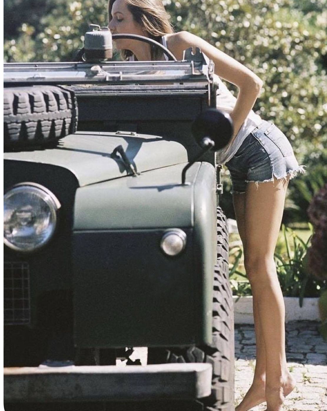 Olive Series Land Rover with woman leaning into cabin