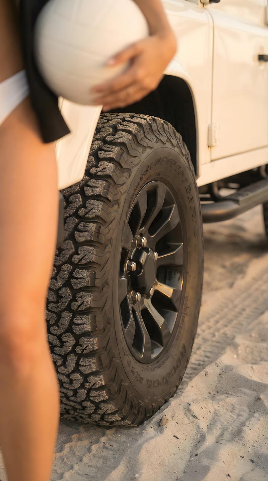 White Defender wheel on beach sand