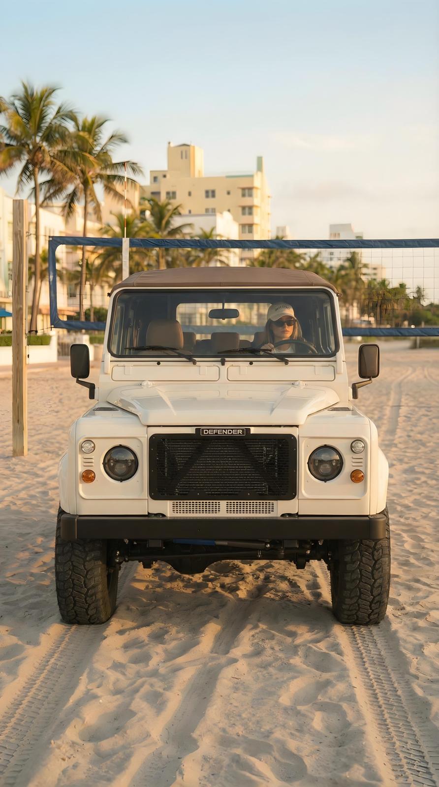 White Defender 90 front on beach at golden hour